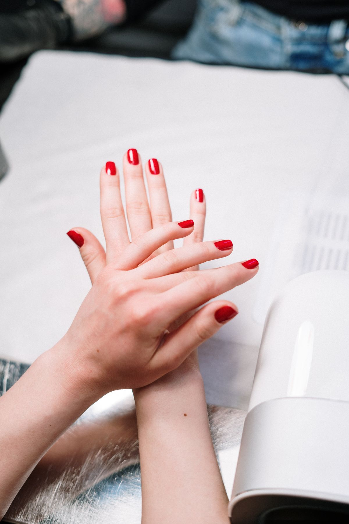 Gel manicure curing under lamp at Noir Haus Nails